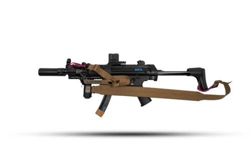 Black tactical rifle with scope and brown strap, photographed in profile.