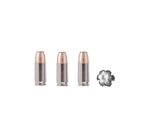 Three nude lipstick bullets in silver tubes arranged in a row with a crumpled metallic wrapper to the right.