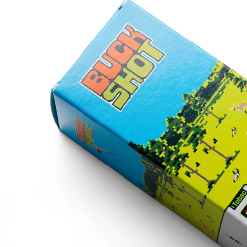 Close-up of a blue toy box with pixelated green and orange graphics and bold lettering on the side, angled on a white surface.